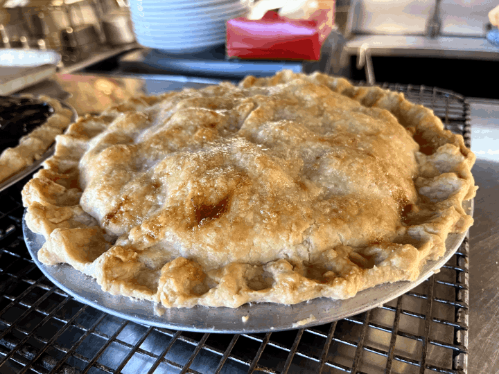 Fresh apple pie cooling on a rack